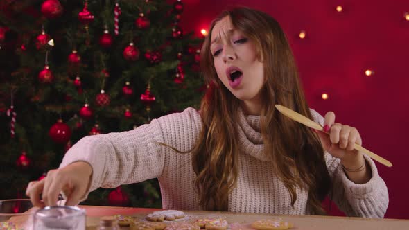 Cute Long-haired Girl Sings Decorating Handmade Gingerbread on Xmas Decoration