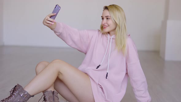 Trendy Young Female Taking Selfie on Floor