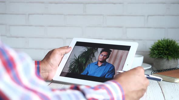 Businessman Holding Digital Tablet Discussing Ideas in Video Conference