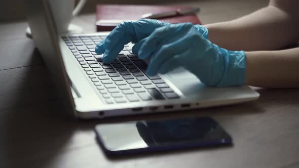 Young Business Man Wears Medical Face Mask Gloves Working on Laptop Computer Sitting at Home Office