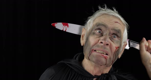 Elderly Man with Knife in Head. Halloween Makeup and Costume. Blood on His Face