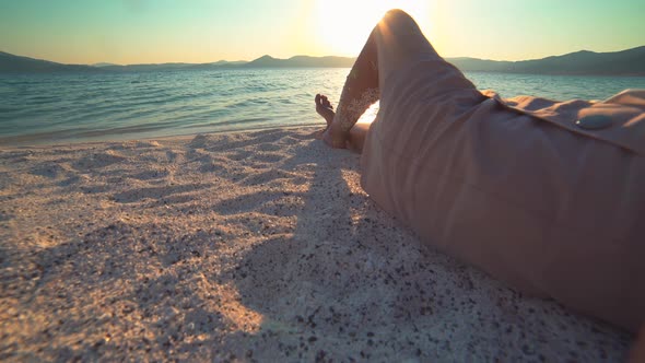 A Female Model is Sunbathing on the White Beach of the Tropical Sea, Lying Down on the Sand