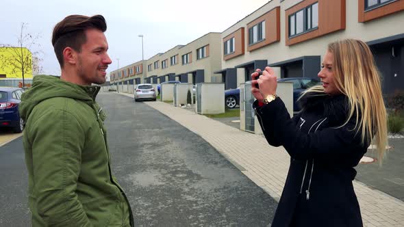 An Attractive Man Poses for an Attractive Woman To Take a Picture of Him on an Empty Street