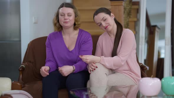 Young Slim Caucasian Millennial Woman Taking Credit Card From Mother Hugging Parent and Smiling