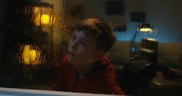 Wheelchaired Boy Watching Storm From Room