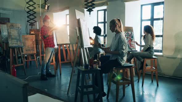 A Man Is Teaching Art To a Group of Students Who Are Drawing