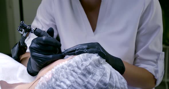 Cosmetologist Is Performing Procedure of Permanent Makeup for Female Client