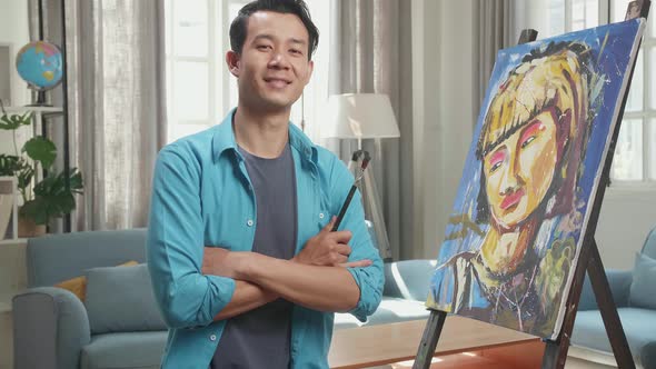 Asian Artist Man Crossing His Arm, And Smiling After Finish Painting