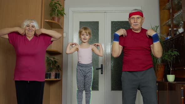 Granddaughter and Mature Grandparents in Sportswear Making Sports Jogging Workout Exercises at Home