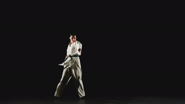 Young Woman in Kimono Practicing Karate Kicks