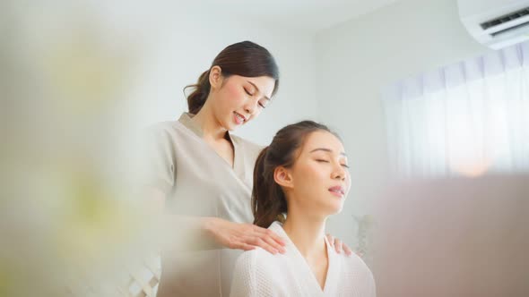 Asian young happy woman feeling relax during shoulder and back massage.