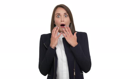 Portrait of Scary Female Young Adult Wearing Classical Suit Being Shocked Raising Hands in Fear