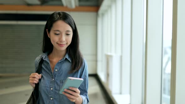 Woman Using Mobile Phone and Walking in Station 