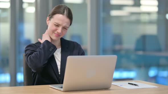 Young Businesswoman having Neck Pain while using Laptop 