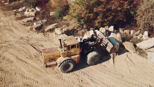 specially equipped machine with a bucket id working near a quarry with stones