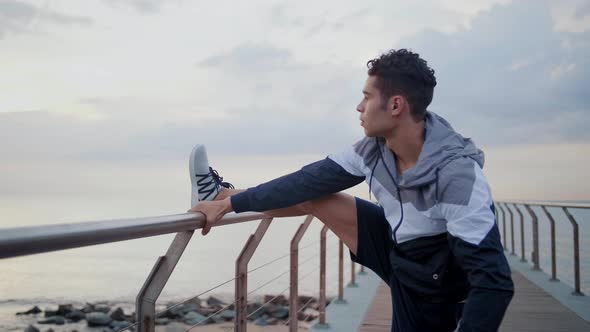 Young attractive athlete stretching and doing exercises on Bridge in the morning.