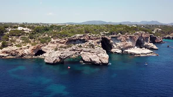 Aerial: Natural arch nearby Cala Santanyi in Mallorca, Spain