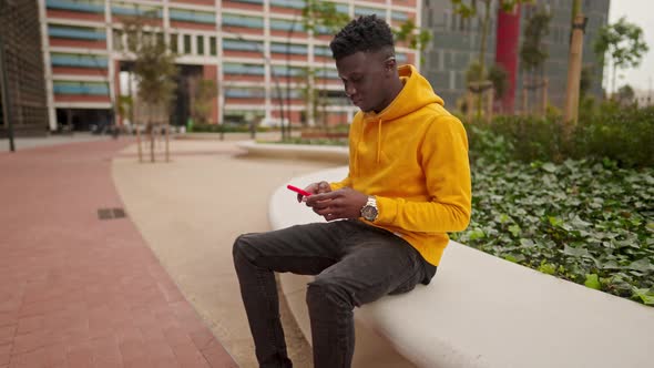 African American Man in a Downtown City Center Chatting with Cellphone