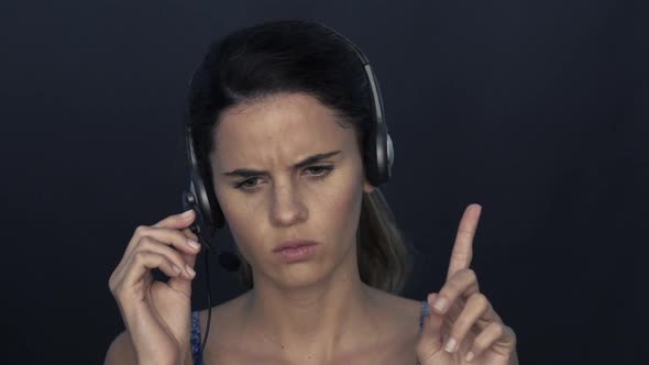 Woman shaking head and forefinger in disapproval while using headset