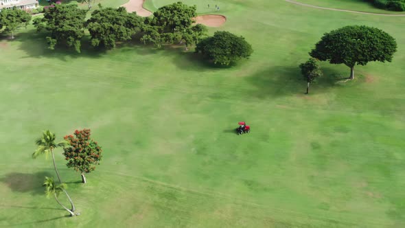 Cinematic View on Lawnmower Cutting Green Grass on Scenic Golf Course