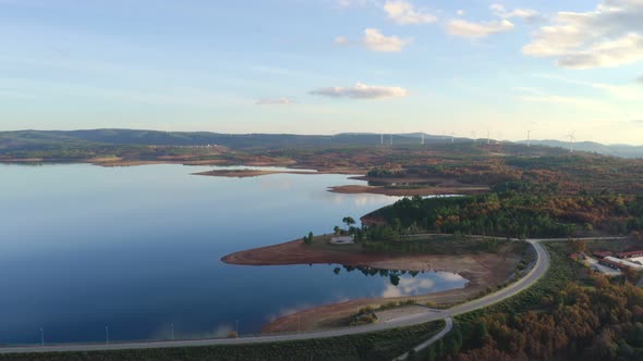 Drone aerial view of a lake reservoir of a dam with perfect reflection on the water of the sunset in