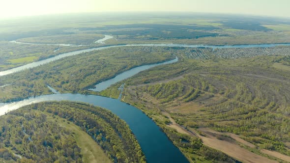 Aerial View Green Forest Woods And Curved River Landscape In Sunny Spring Day