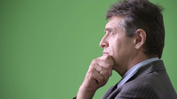 Mature Handsome Businessman Against Green Background