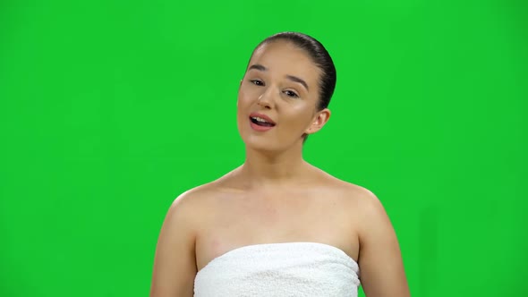 Girl with Bare Shoulders in White Towel Tells Informations on Green Screen at Studio