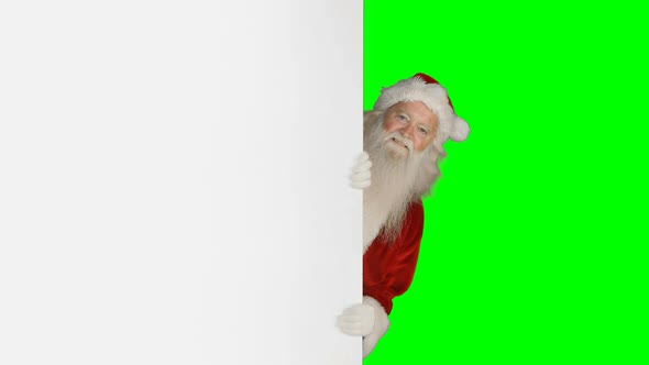 Surprised santa claus hiding behind white screen