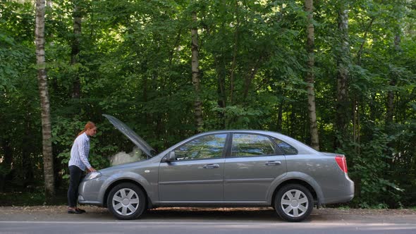 Business Woman a Broken Car and Opens the Hood in the Forest