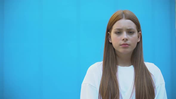 Serious Teenage Girl Posing Before Camera Blue Background, Awkward Age, Template