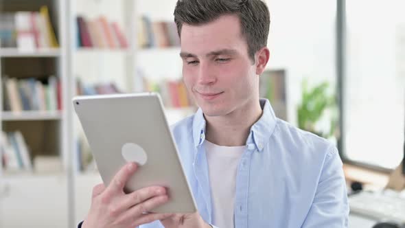 Cheerful Young Man Using Tablet PC
