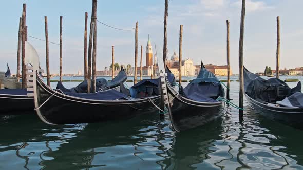 Docked Empty Gondolas on Wooden Mooring Piles Venice Italy