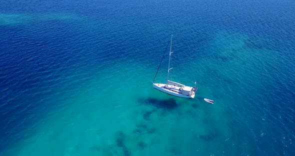 Wide angle flying clean view of a white sand paradise beach and blue water background