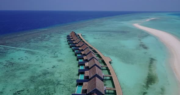 Wide aerial island view of a white sand paradise beach and aqua turquoise water background in hi res