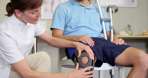 Physiotherapist examining patient's knee