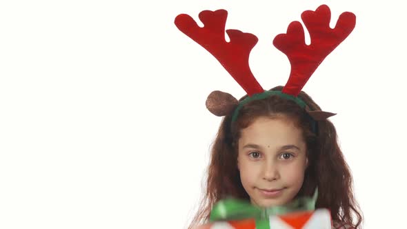 A Sweet Girl Hides Behind a Christmas Gift Box