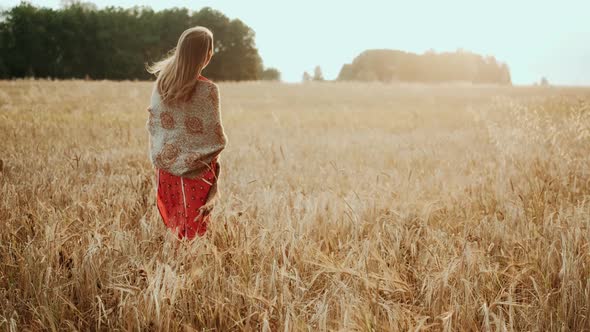 Young Farmer Girl Walking Through Wheat Field at Sunset. Modern Farming, Happy Youth and Profession