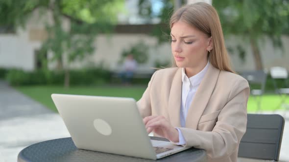 Young Businesswoman with Laptop Having Wrist Pain in Outdoor Cafe