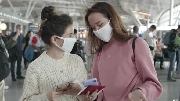 Two Women in Medical Mask Portrait Laughing and Talking in Airport Terminal Preventing Themselves