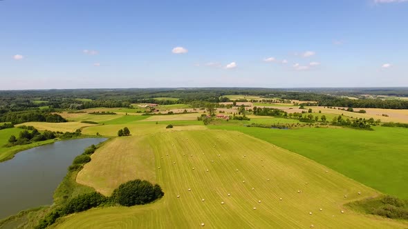 Field with haystacks in rural landscape, top view