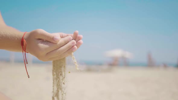 Sand As the Time Slips Through Your Fingers. Little Girl Holding a Sand Sea Background. Sand in Your