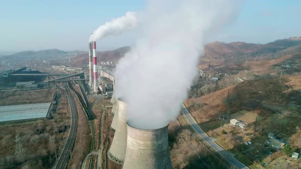 Aerial Orbital View of an Industrial Zone Pipes Pouring Thick White Smoke