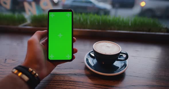 POV Male Hand Using Smartphone with Green Screen in Cafe