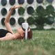 A young woman lying on the grass while trying virtual reality goggles - VideoHive Item for Sale
