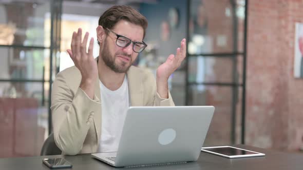 Young Man with Laptop Having Loss Failure