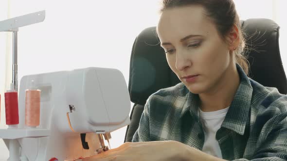 Close up of professional woman tailor sews on sewing machine.