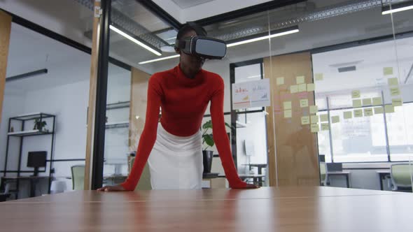 African american woman wearing vr headset at modern office