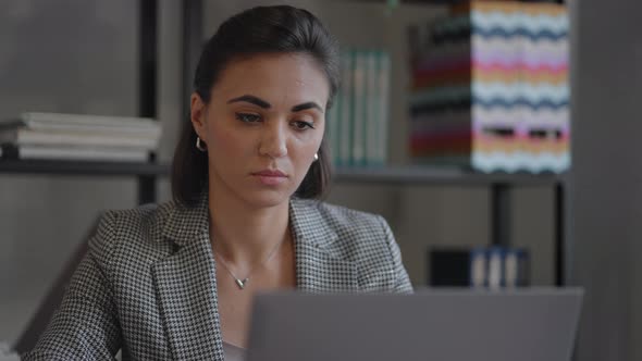 A Young Beautiful Woman is Sitting on a Chair and Writing Down or Taking Down Notes While Attending