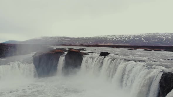 Woman standing on rock to admire waterfall